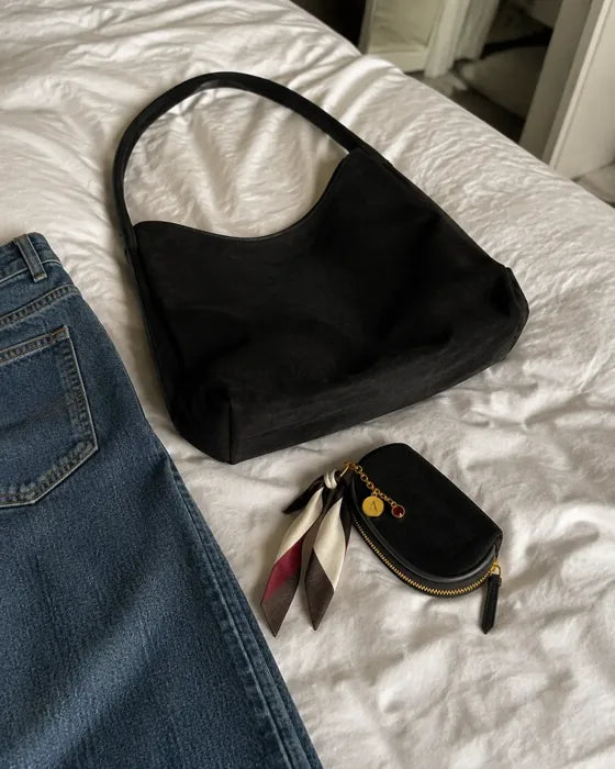Lifestyle imagery: Black Porter 24 and styled Black Mini on a bed
